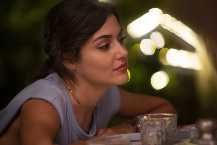 Hande Erçel poartă un maiou de culoare mov și are părul prins