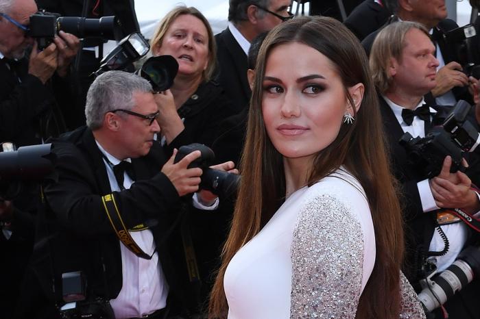 Fahriye Evcen poartă o rochie albă cu mâneci lungi și are părul desprins