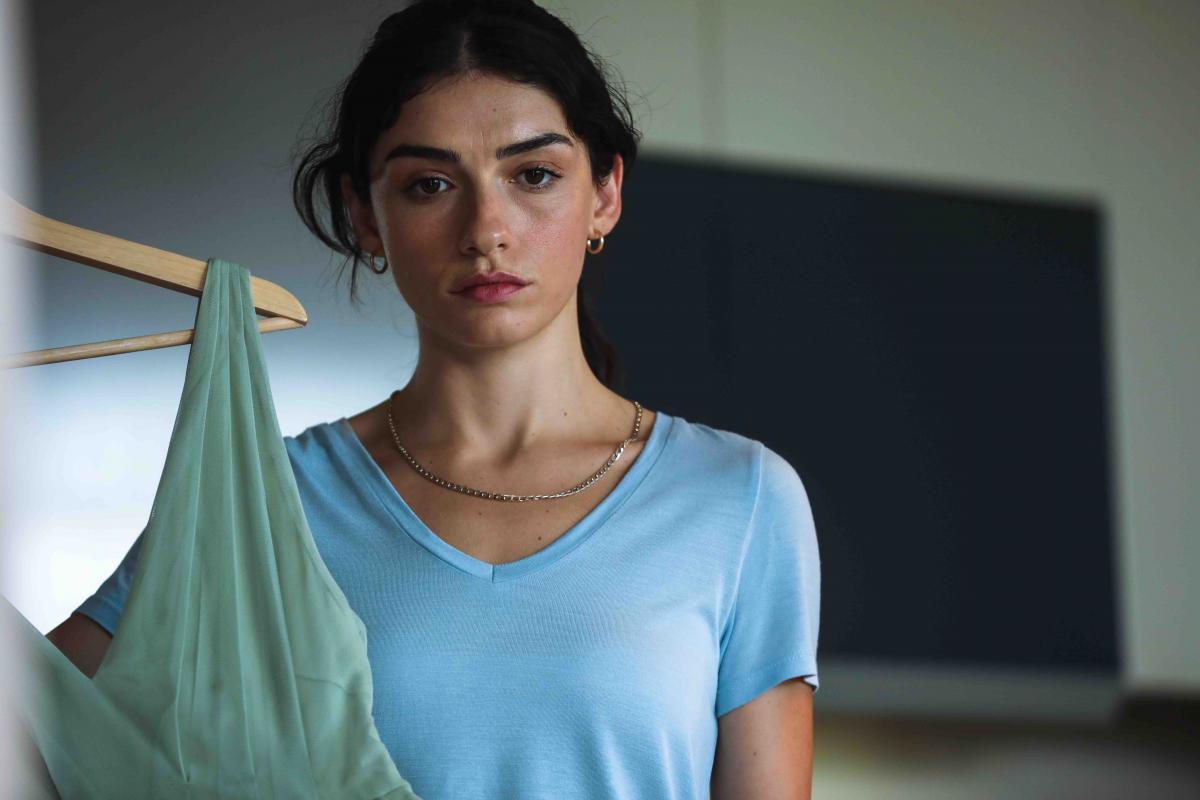 Hazar Ergüçlü poartă un tricou albastru și are părul prins