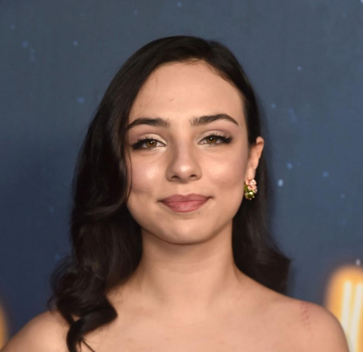 Fiona Palomo are părul desprins, brunet și poartă un machiaj de seară