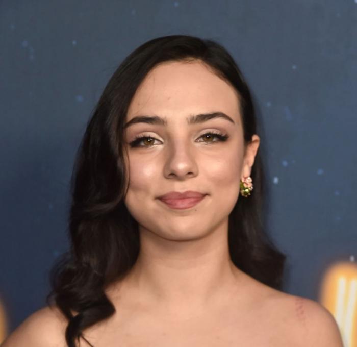 Fiona Palomo are părul desprins, brunet și poartă un machiaj de seară