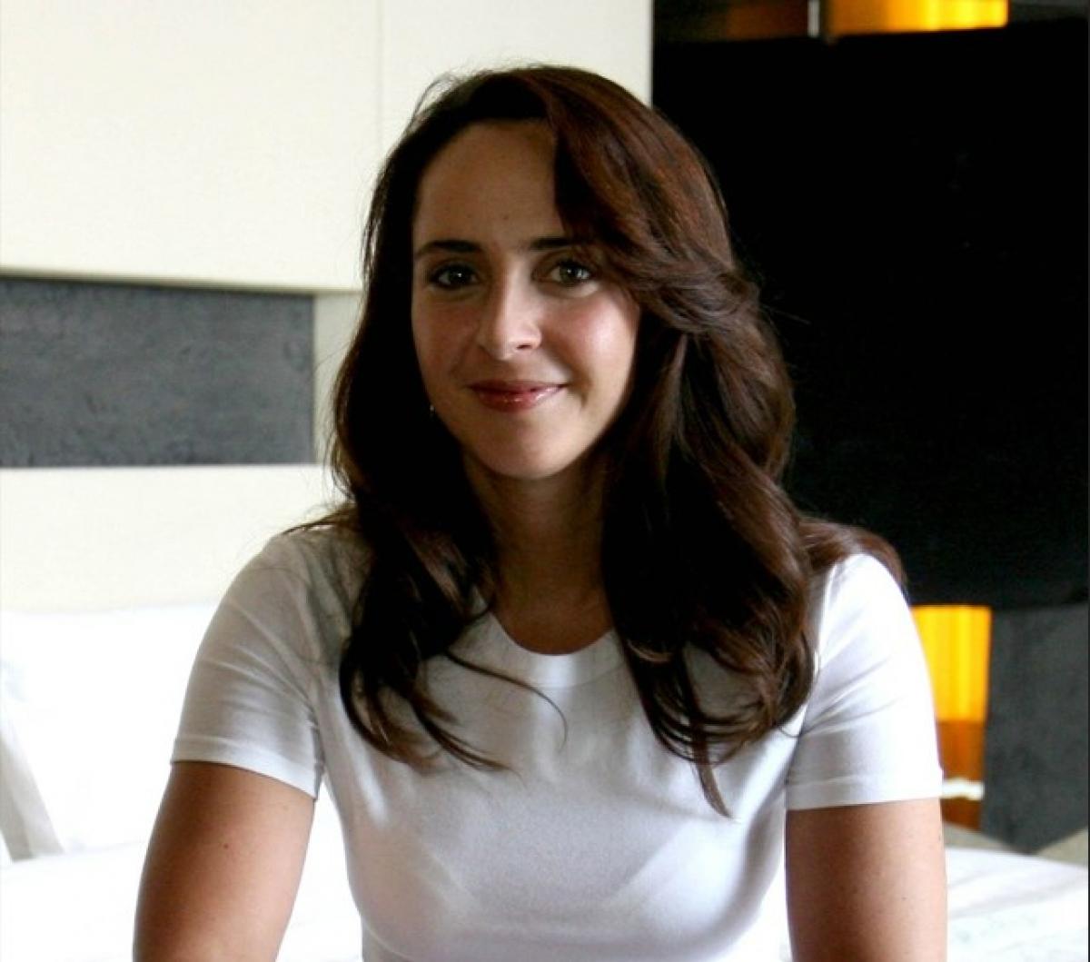 Irán Castillo zâmbește. Actrița poartă un tricou alb și are părul desprins