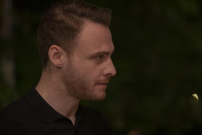 Kerem Bürsin poartă un tricou închis la culoare