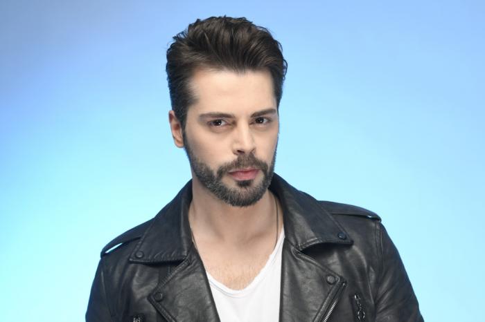 Ali Yasin Özegemen poartă o cămașă albă și o geacă neagră de piele