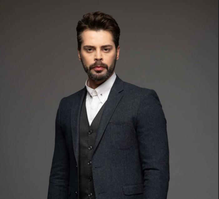 Ali Yasin Özegemen poartă o cămașă albă și un sacou negru