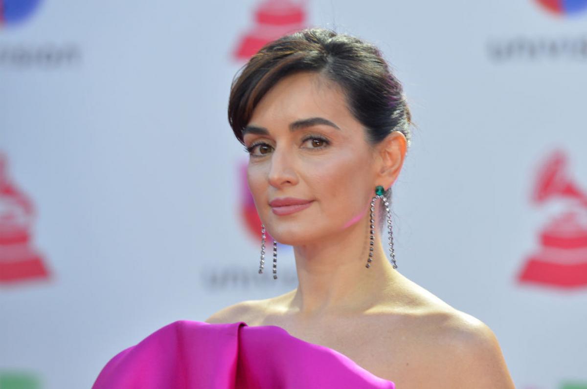 Ana de la Reguera poartă o rochie mov, fără mâneci și părul prins.