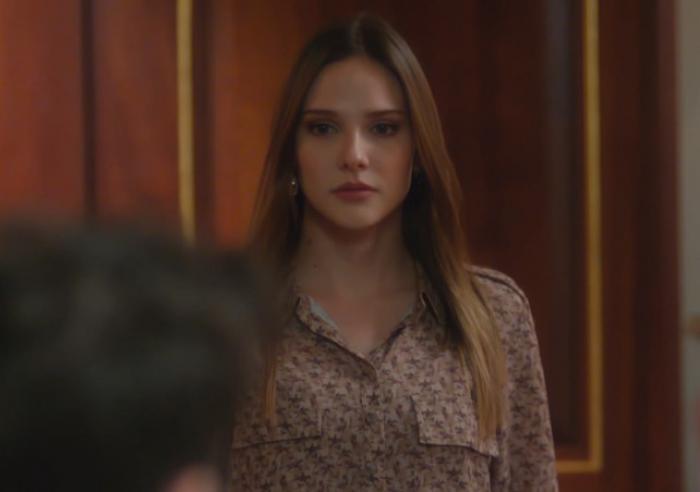Alina Boz poartă o bluză cu mâneci lungi cu flori și are părul desprins