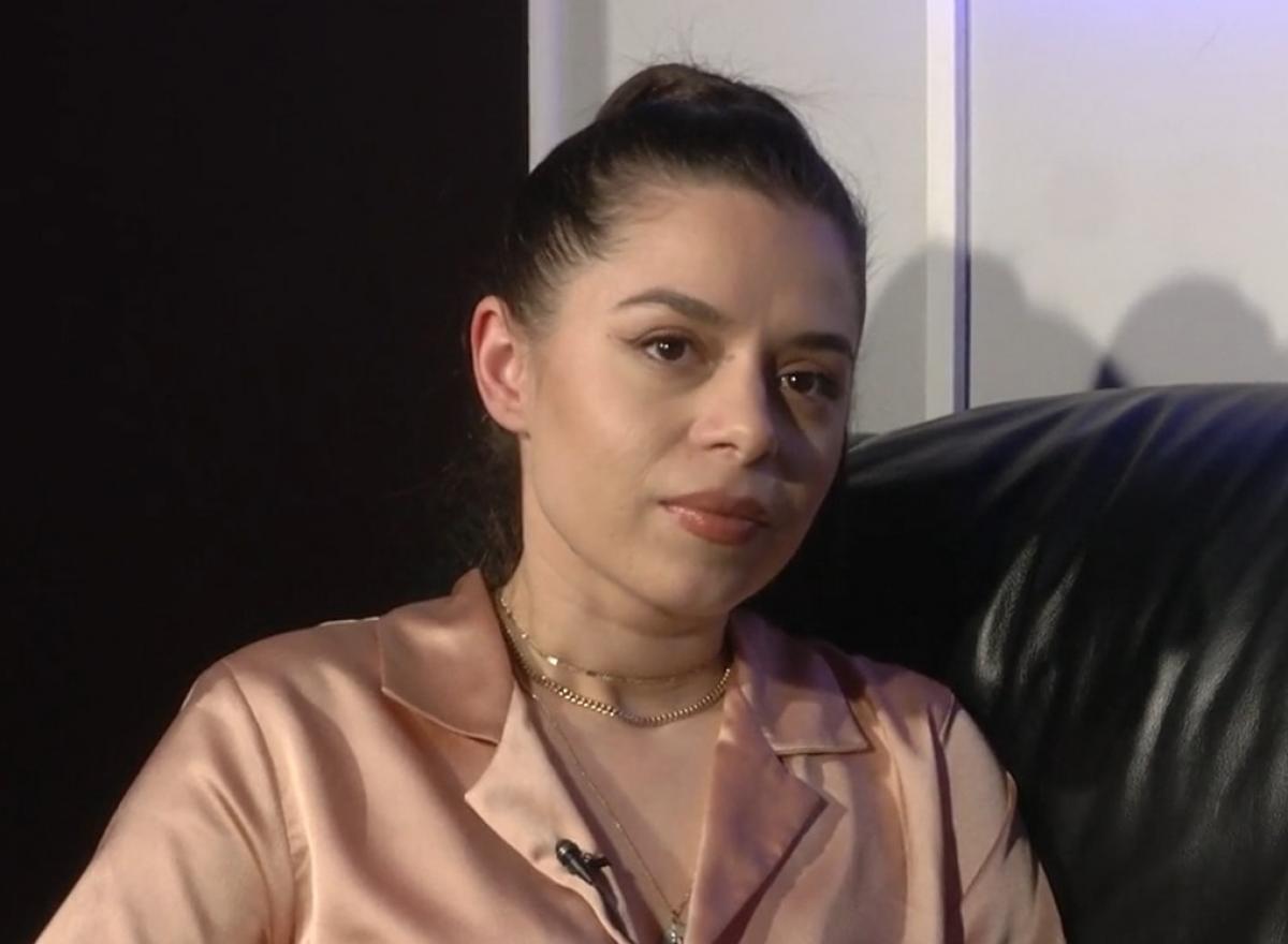 Eugenia Nicolae poartă o cămașă roz pal și are părul prins într-o coadă de cal