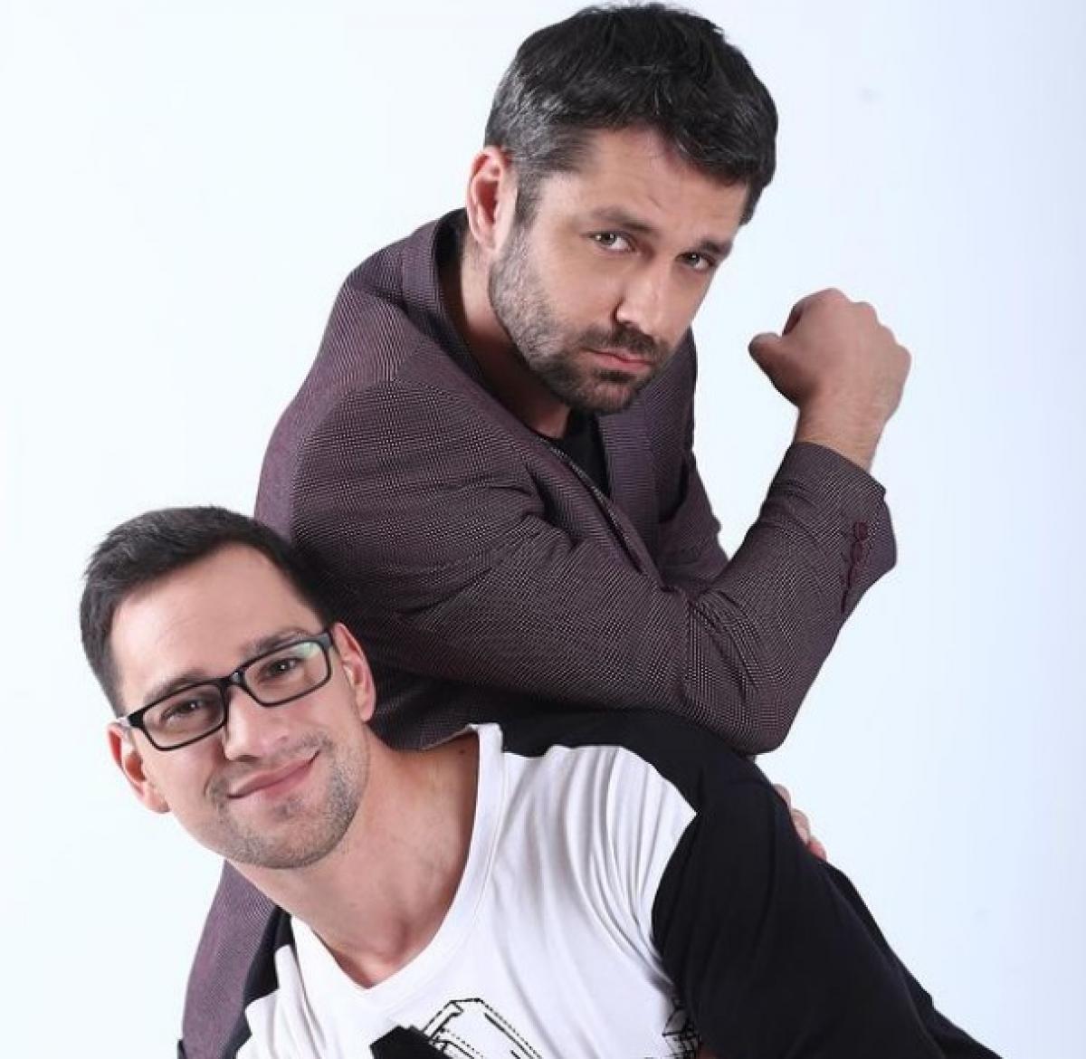 Alecsandru Dunaev își sprijină cotul pe Vlad Gherman și amândoi privesc zâmbind spre cameră