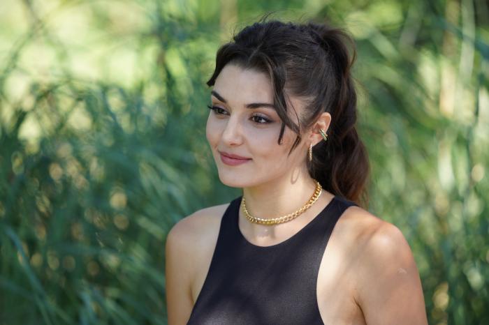 Hande Erçel poartă un maiou negru și are părul prins într-o coadă de cal