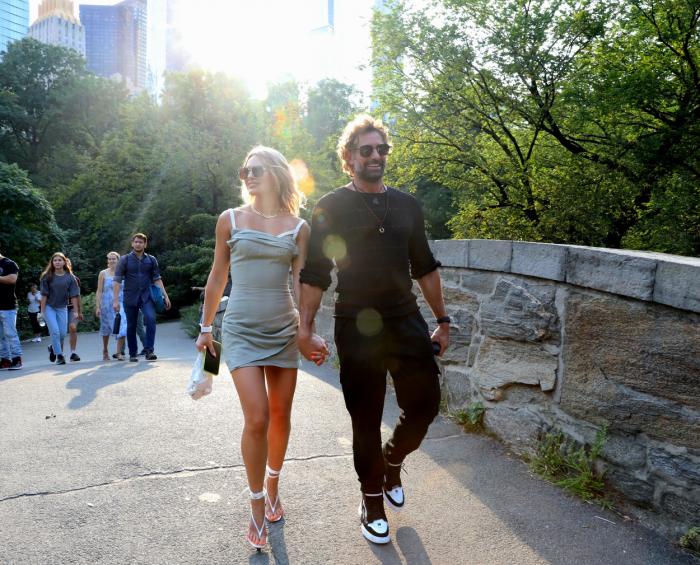 Gabriel Soto este îmbrăcat în negru și se ține de mână cu Irina Baeva care poartă o rochie scurtă și are părul desprins