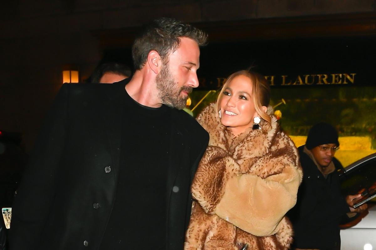 Jennifer Lopez stă alături de Ben Affleck și zâmbește. Vedeta poartă o haină de blană