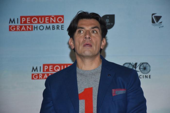 Jorge Salinas poartă un tricou gri și un sacou albastru