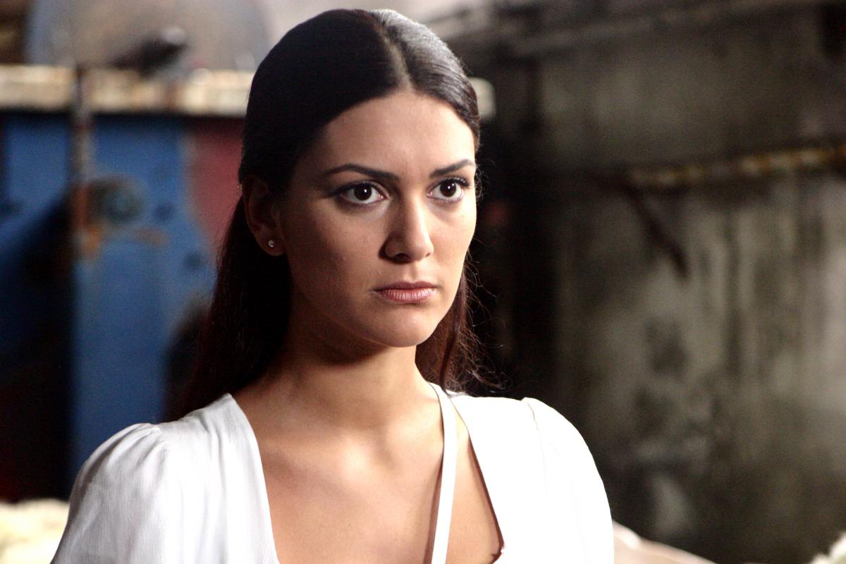 Bergüzar Korel poartă o rochie albă și are părul lung