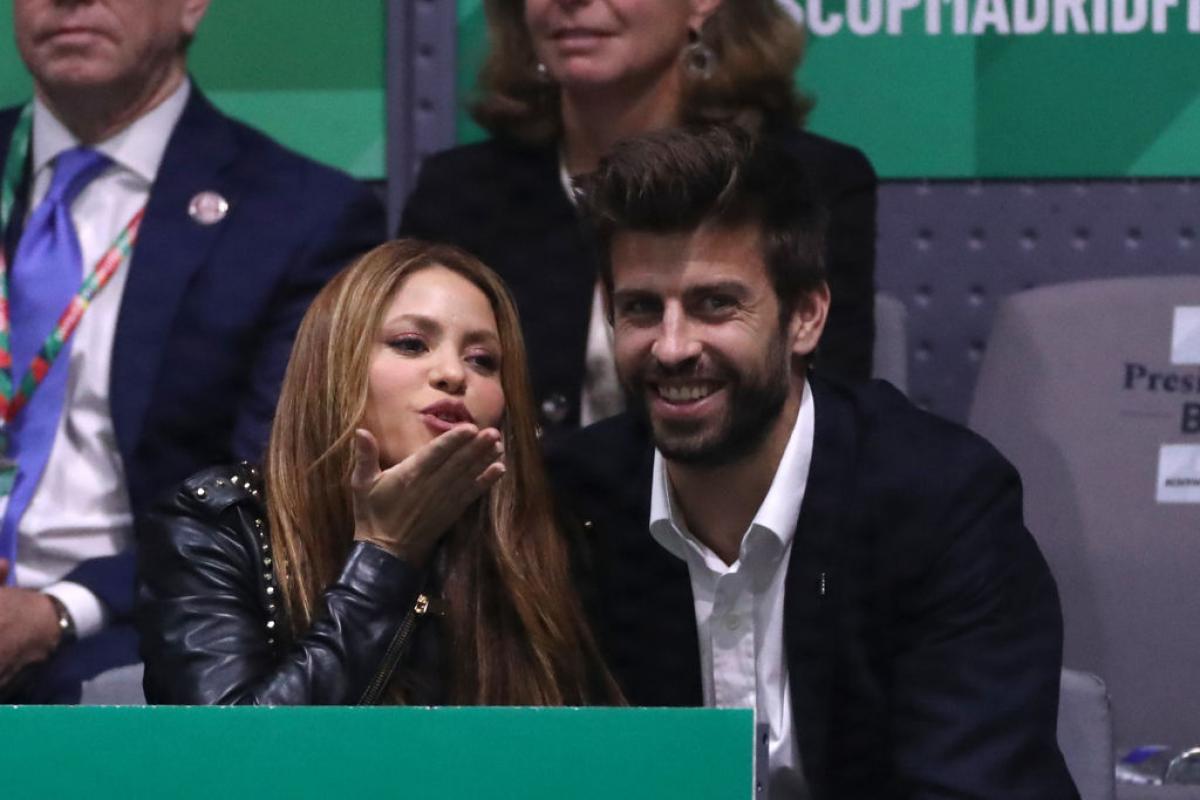 Shakira poartă o geacă de piele neagră, stă lângă Gerard Pique care zâmbește
