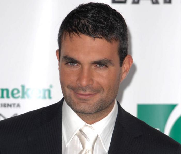 Mauricio Islas poartă costum și zâmbește