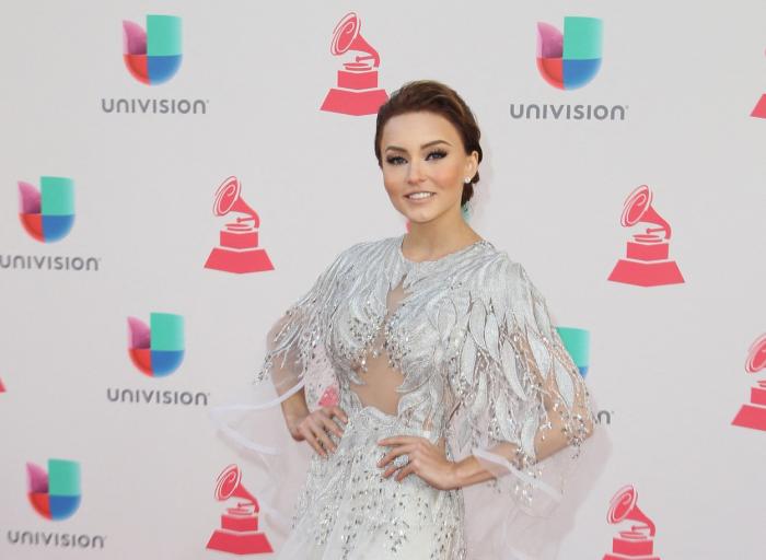 Angelique Boyer poartă o rochie de seară, stă cu mâinile în șold și are părul prins în coc purtat jos