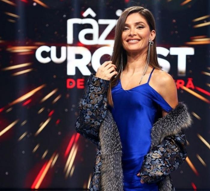 Alina Pușcaș poartă o rochie albastră și zâmbește