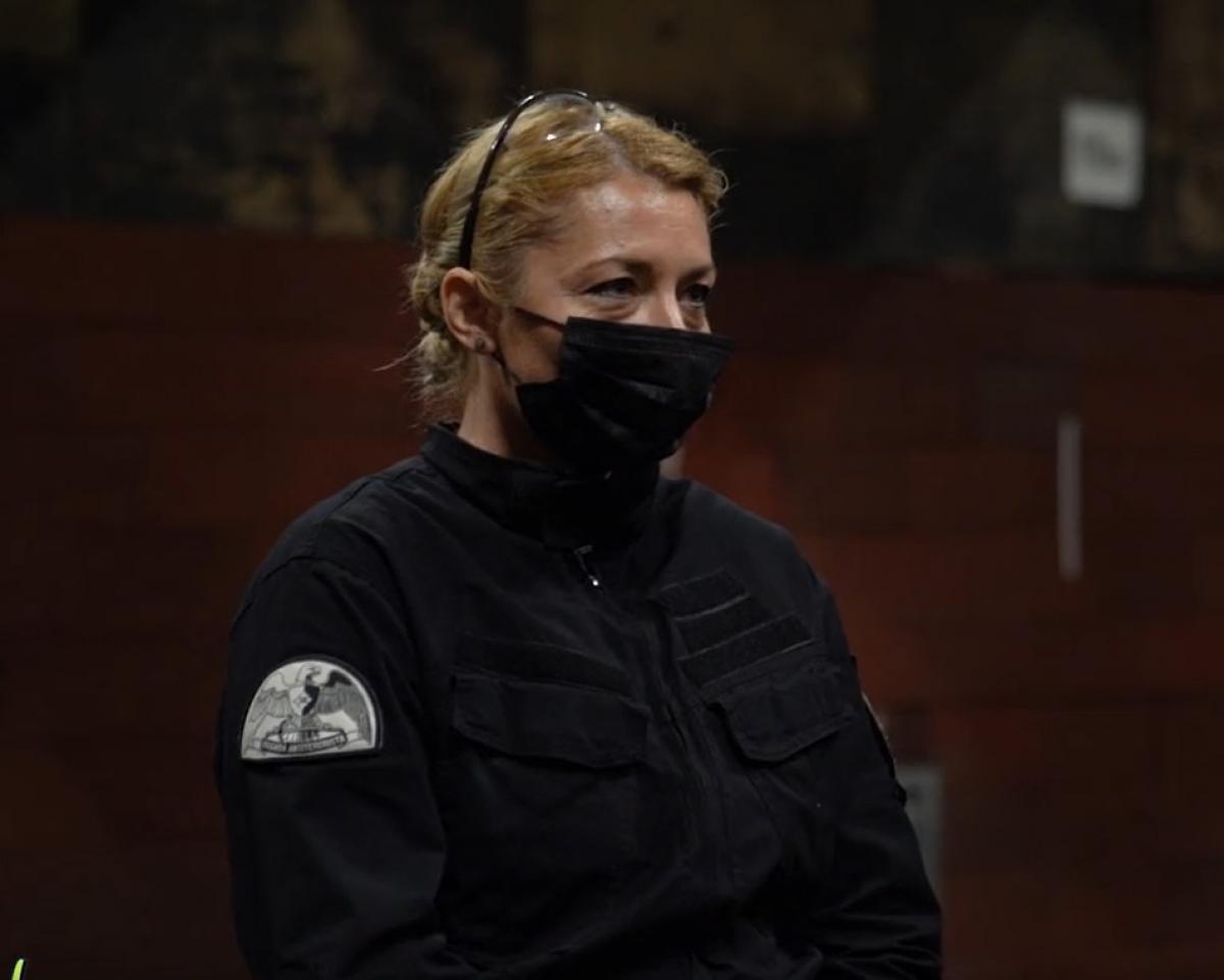 Alina este îmbrăcată în uniformă, poartă mască și părul prins. Este blondă