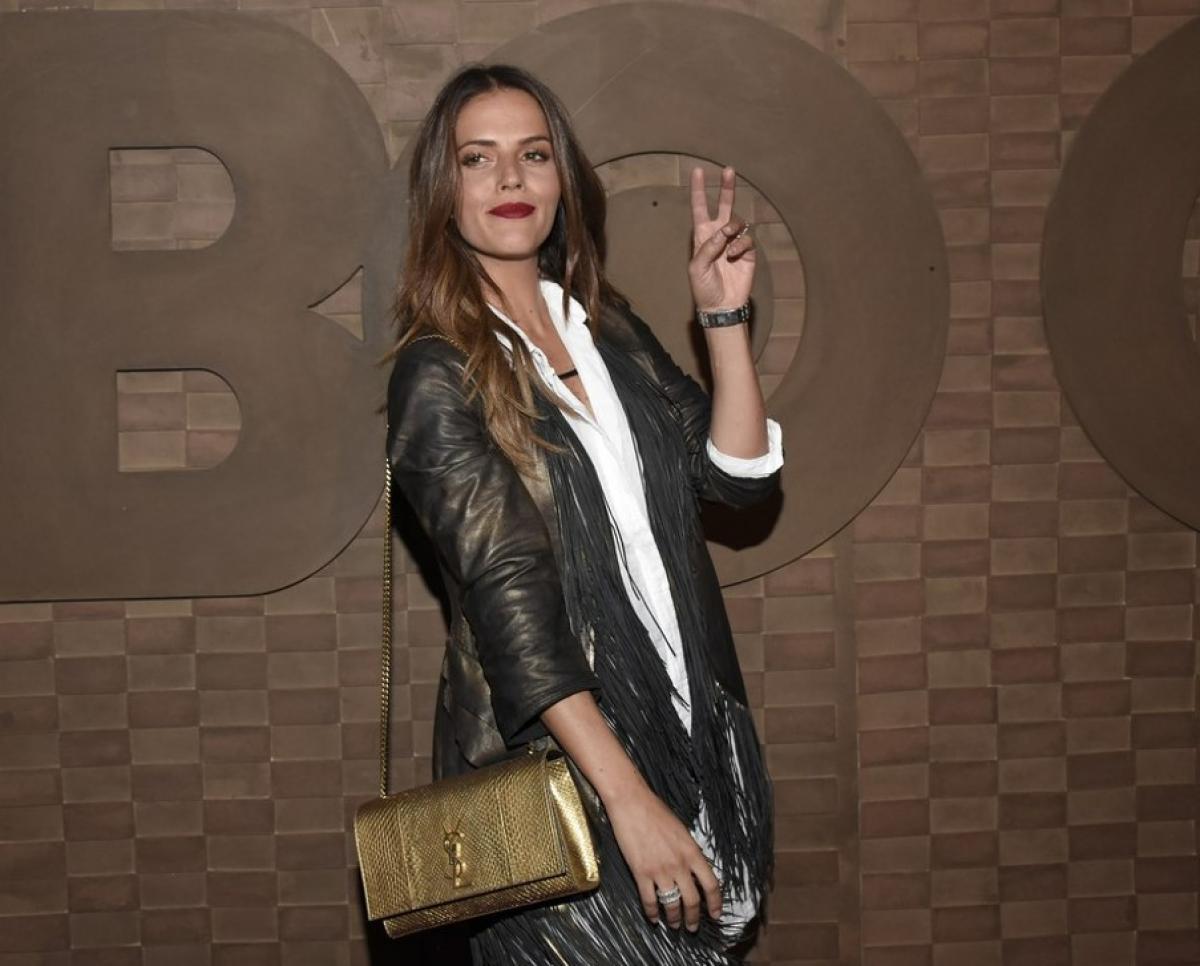 Claudia Álvarez poartă o geacă neagră de piele și ridică două degete în sus