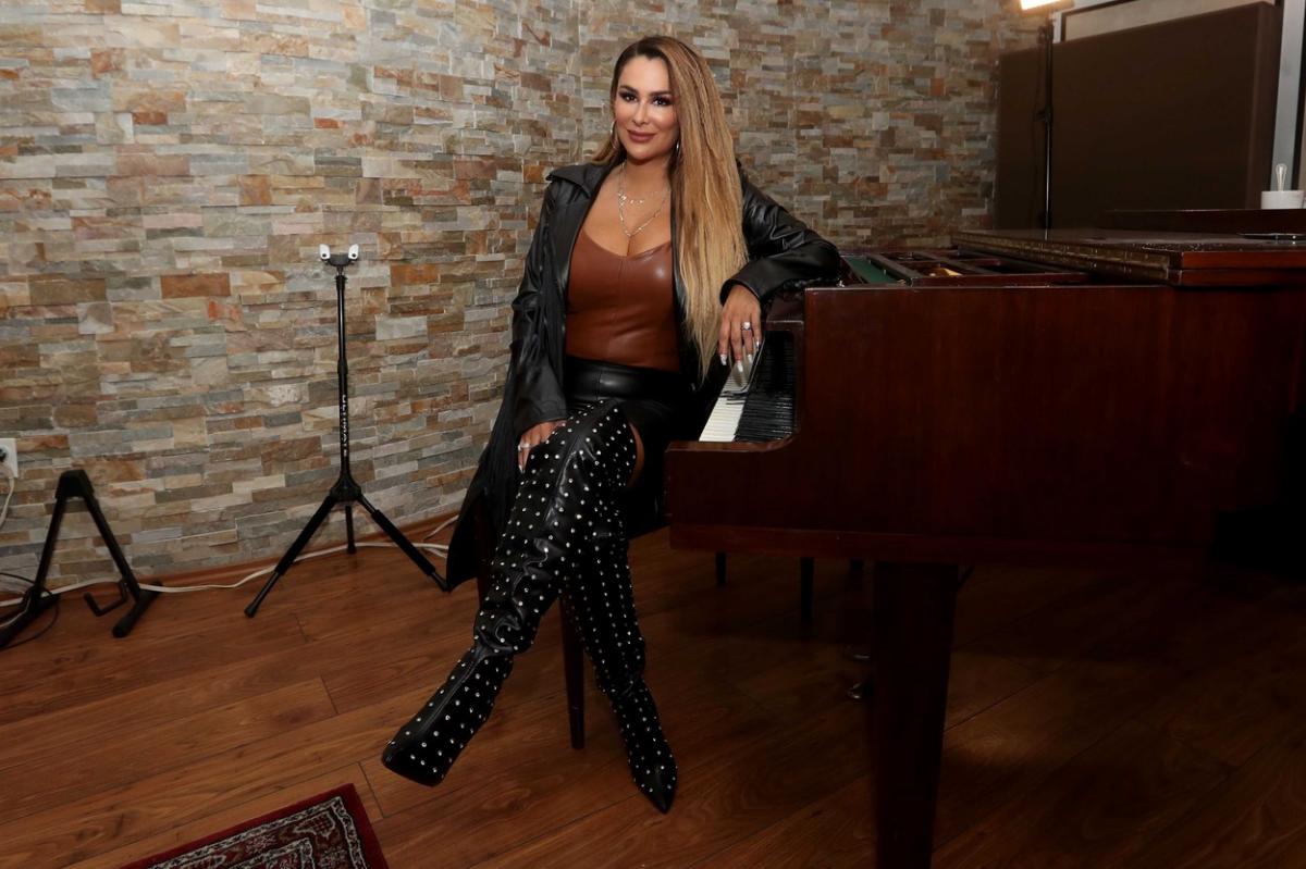 Ninel Conde stă picior peste picior, are părul desprins și lung