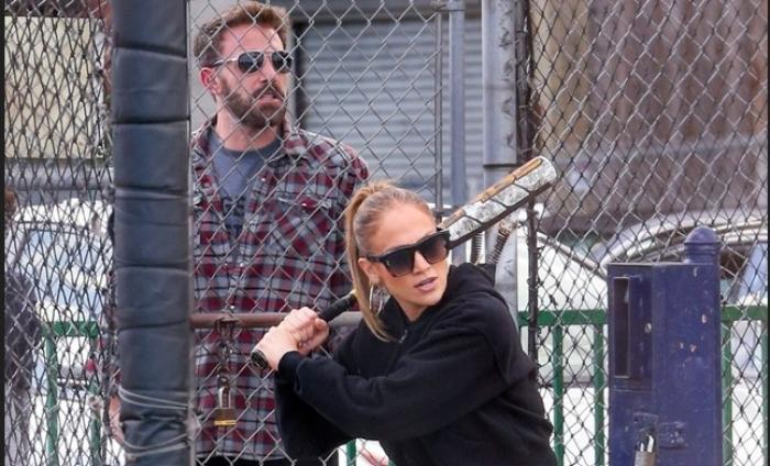 Jennifer López poartă un costum sport all-black și ține o bâtă de baseball în mână