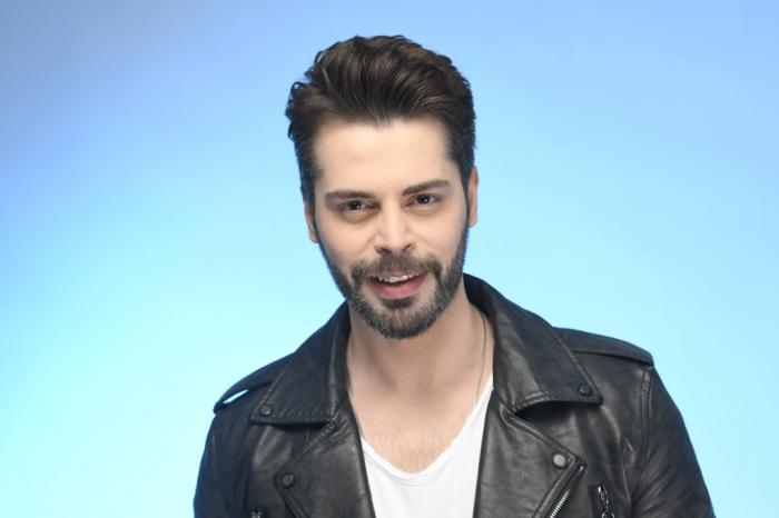 Ali Yasin Özegemen poartă un tricou alb și geacă neagră, de piele