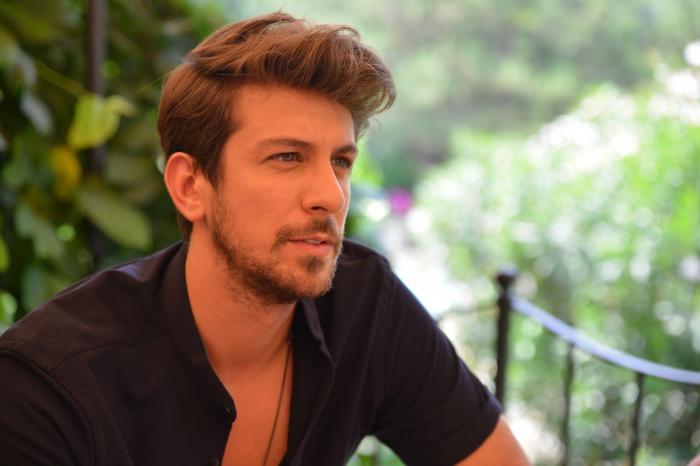 Birand Tunca poartă o cămașă neagră cu mânecă scurtă