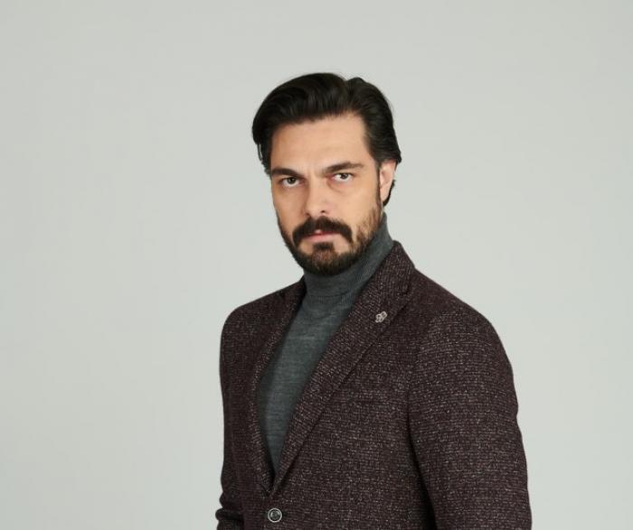 Halil İbrahim Ceyhan poartă maletă închisă la culoare și are o mină serioasă