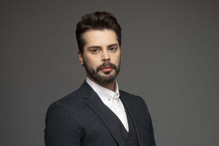 Ali Yasin Özegemen poartă o cămașă albă și sacou negru