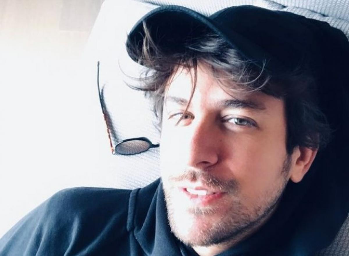 Birand Tunca poartă un hanorac negru și șapcă