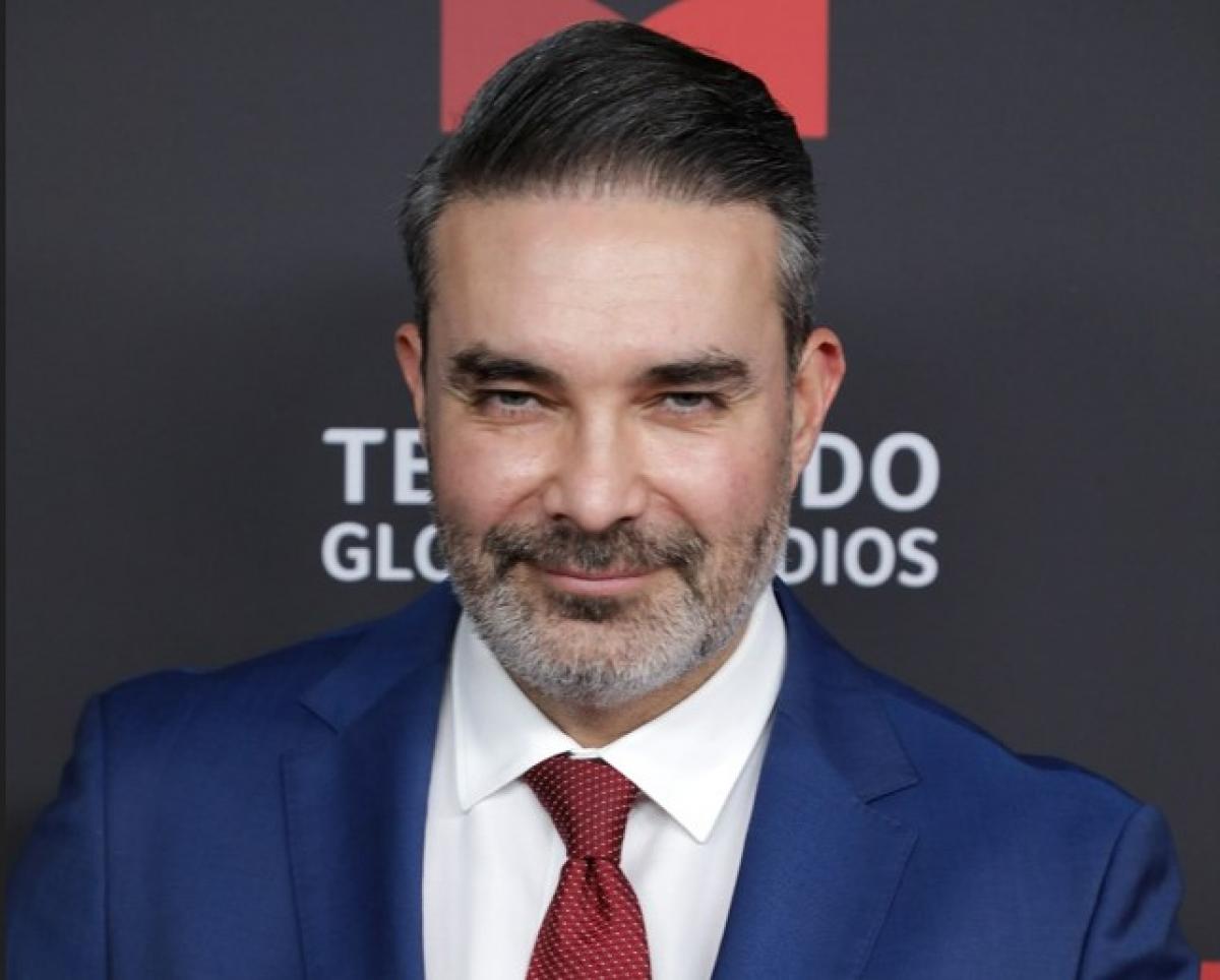 Mauricio Islas poartă o cămașă albă, costum albastru și are mustață