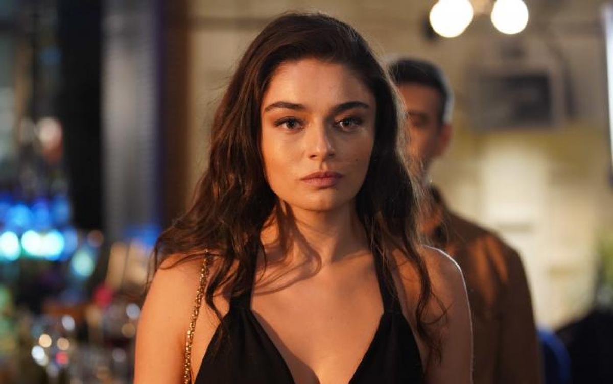 Ayça Ayşin Turan poartă o rochie neagră fără mâneci și are părul desprins