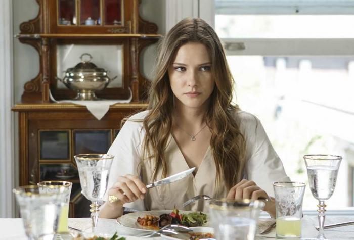 Alina Boz stă la masă cu farfuria de mâncare în față și se uită într-o parte