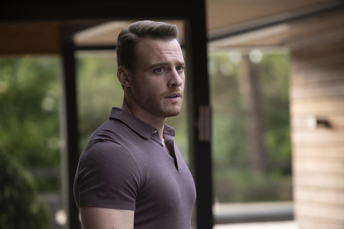 Kerem Bürsin poartă un tricou gri și se uită în depărtare
