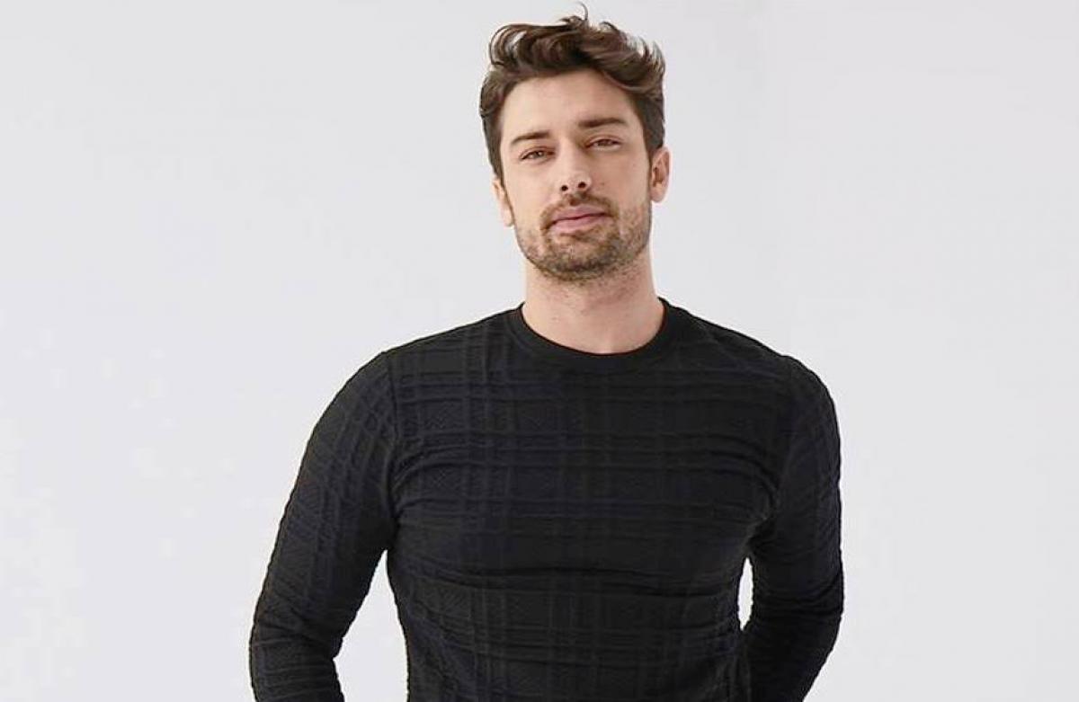 Alp Navruz poartă o bluză neagră cu mâneci lungi