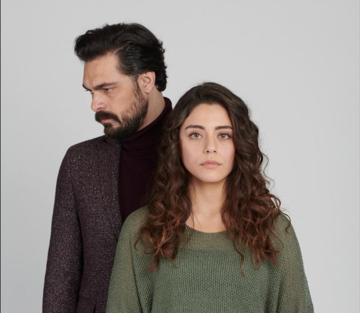 Halil Ibrahim Ceyhan poartă o maletă neagră și un sacou de aceeași culoare, iar Sıla Türkoğlu are o bluză verde kaki cu mâneci lungi