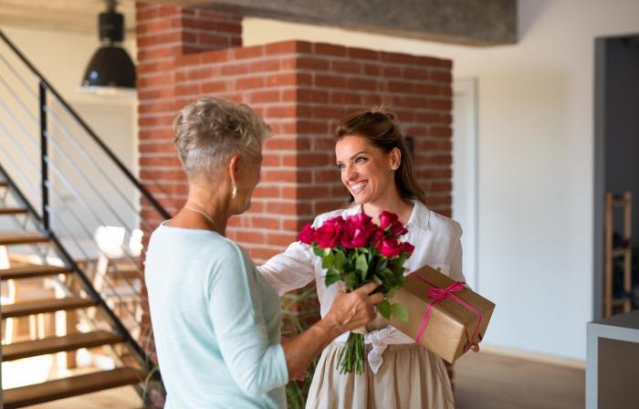Un bărbat oferă unei femei un buchet de flori roșii