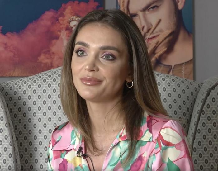 Specialistul Cultour 2022 poartă o bluză înflorată, are părul lung, desprins și zâmbește ușor