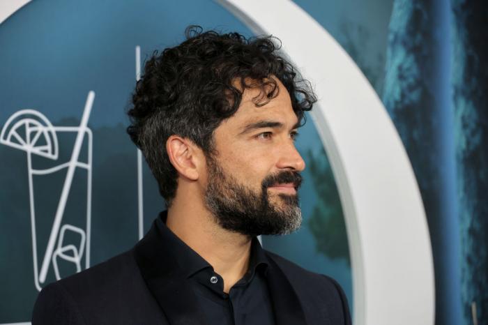 Alfonso Herrera poartă o cămașă neagră și un sacou de aceeași culoare