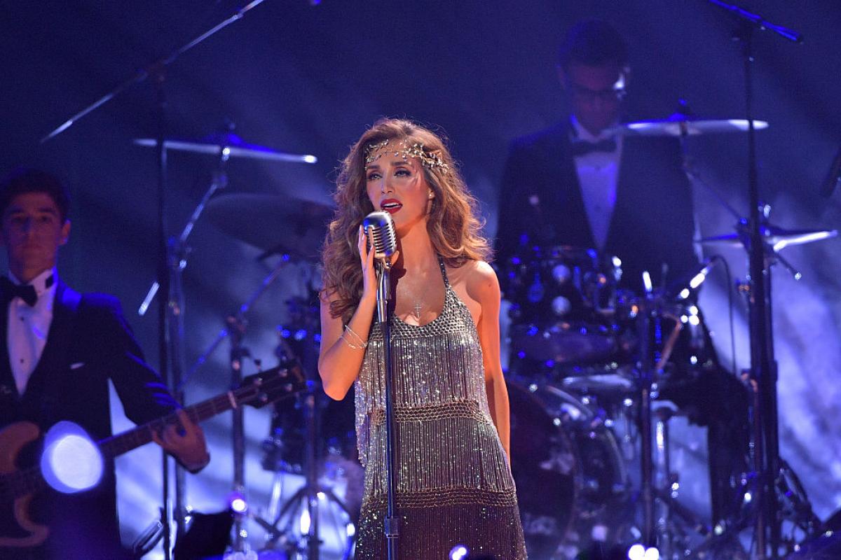 Anahí poartă o rochie cu paiete și se află pe scenă