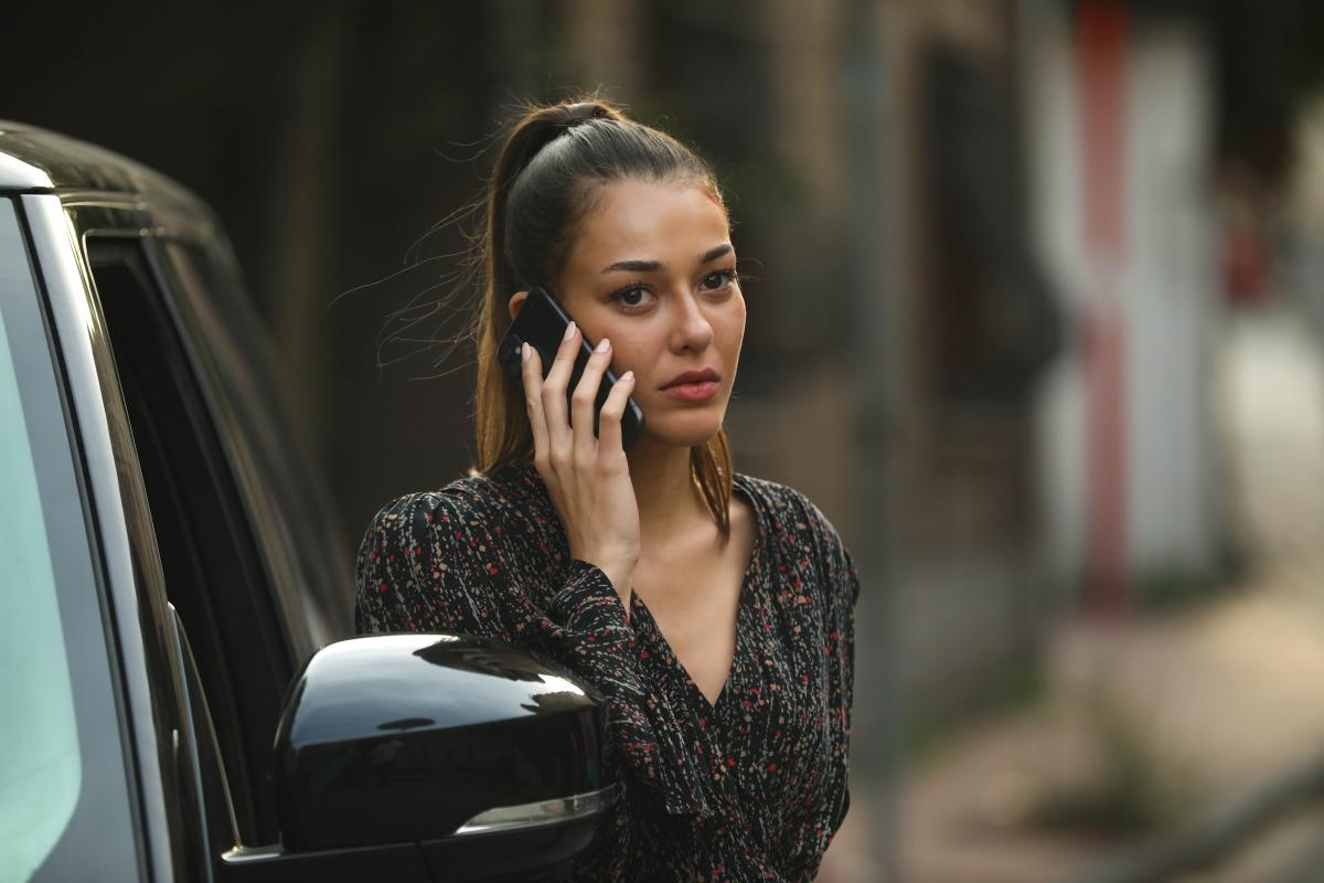 Dilan Çiçek Deniz poartă o rochie închisă la culoare și are părul prins în coadă de cal și vorbește la telefon