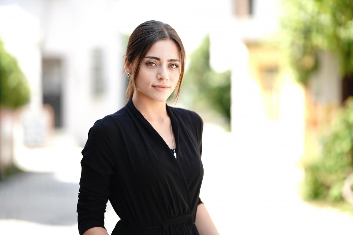 Sıla Türkoğlu poartă o rochie neagră, are părul prins într-o coadă de cal și două șuvițe lăsate pe față