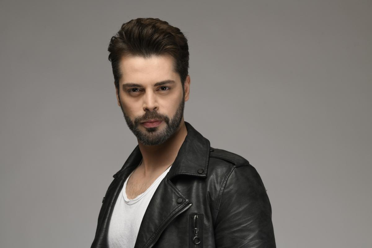 Ali Yasin Özegemen poartă un tricou alb și geacă neagră de piele