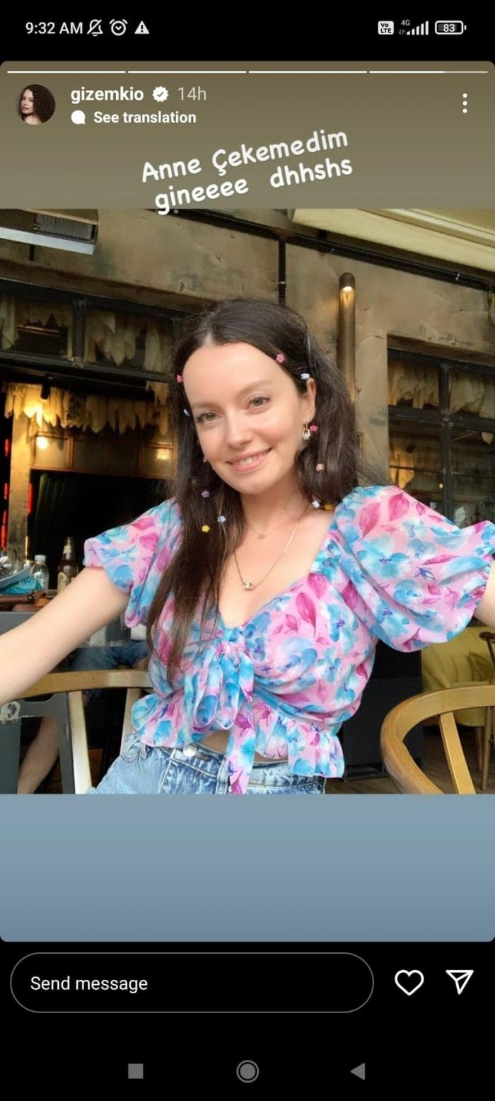 Gizem Arikan poartă o bluză cu flori și zâmbește