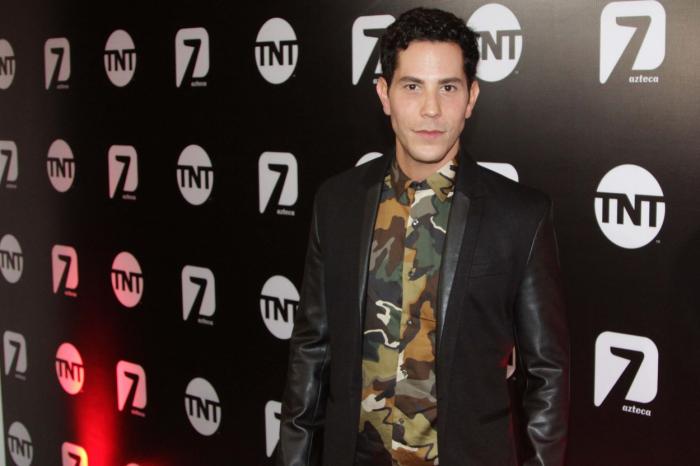 Christian Chávez poartă un tricou cu imprimeu și o geacă neagră de blugi