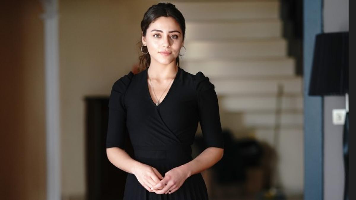 Sıla Türkoğlu poartă o rochie neagră și are părul prins în coadă