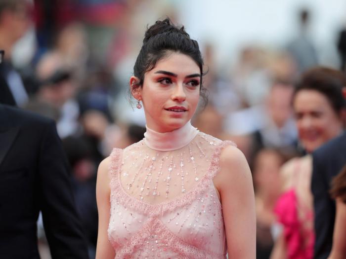 Hazar Ergüçlü poartă o rochie roz fără mâneci și are părul prins