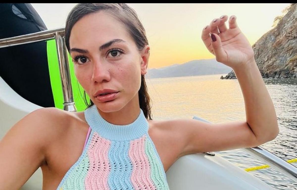 Demet Özdemir poartă un top fără mâneci și își ține mâna stângă puțin ridicată