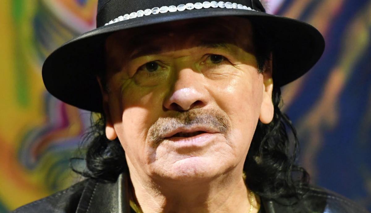 Carlos Santana poartă pălărie și ține gura deschisă